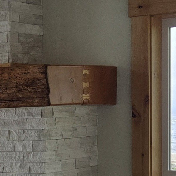 Casey Jay Winters Construction rustic mantle beam with bowtie joints on stone fireplace, Tillamook Oregon